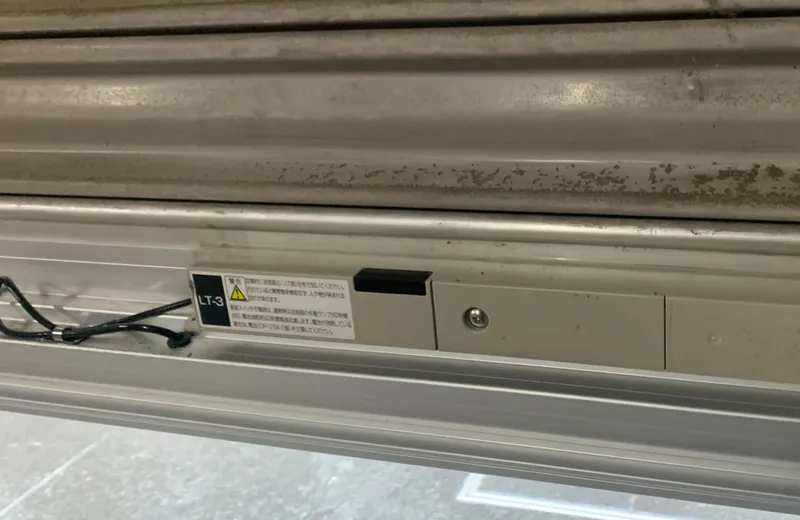 中央区のマンション駐車場で交換した、電動シャッター下部の障害物検知装置。工事完了報告の写真