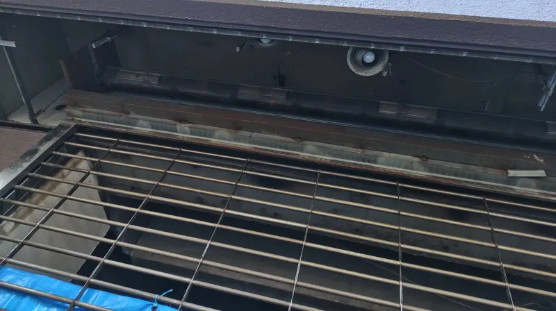 港区のマンション1階店舗で、天井を開けた状態の既存の防火シャッターとグリルシャッター